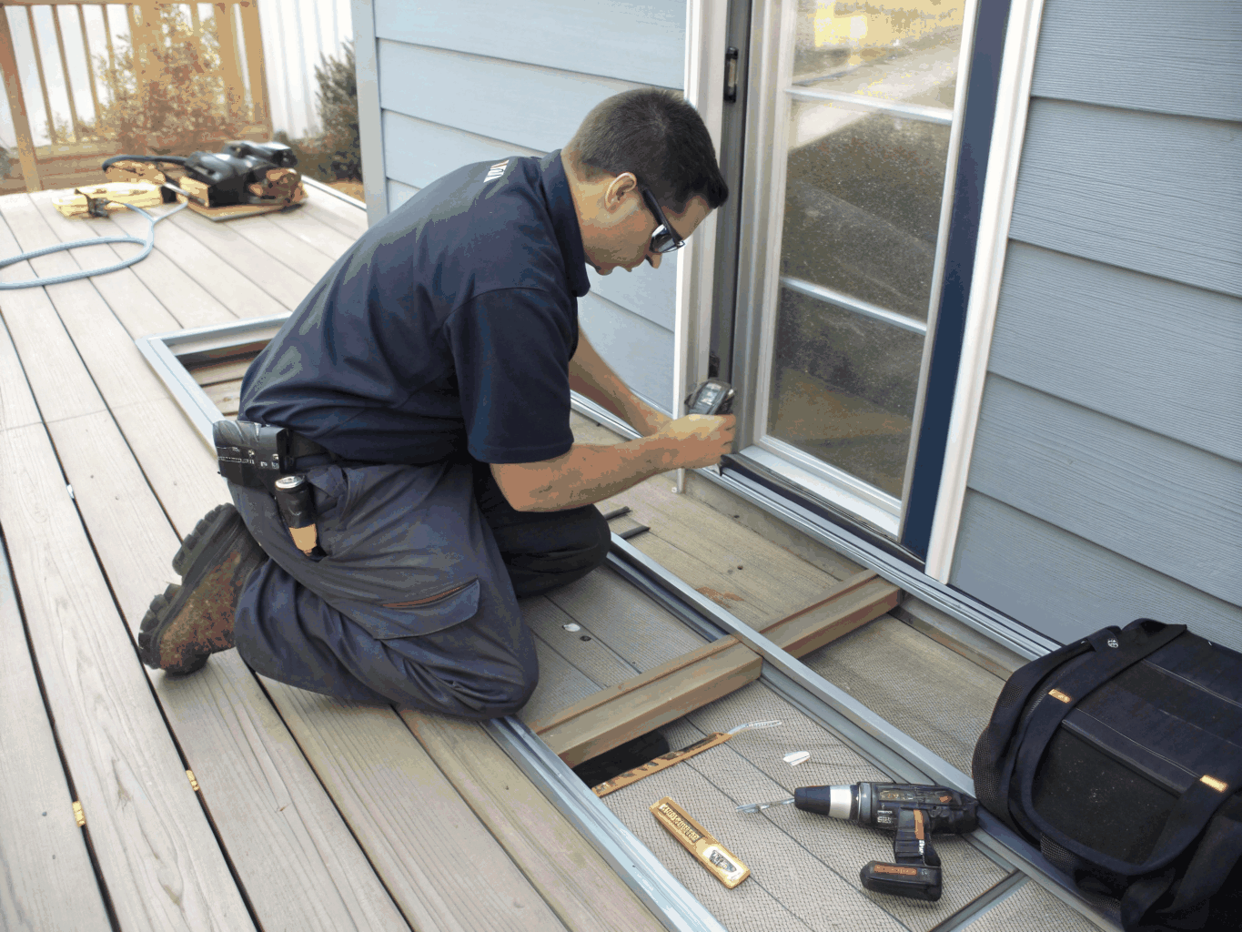 Technicien réparant une porte patio coulissante